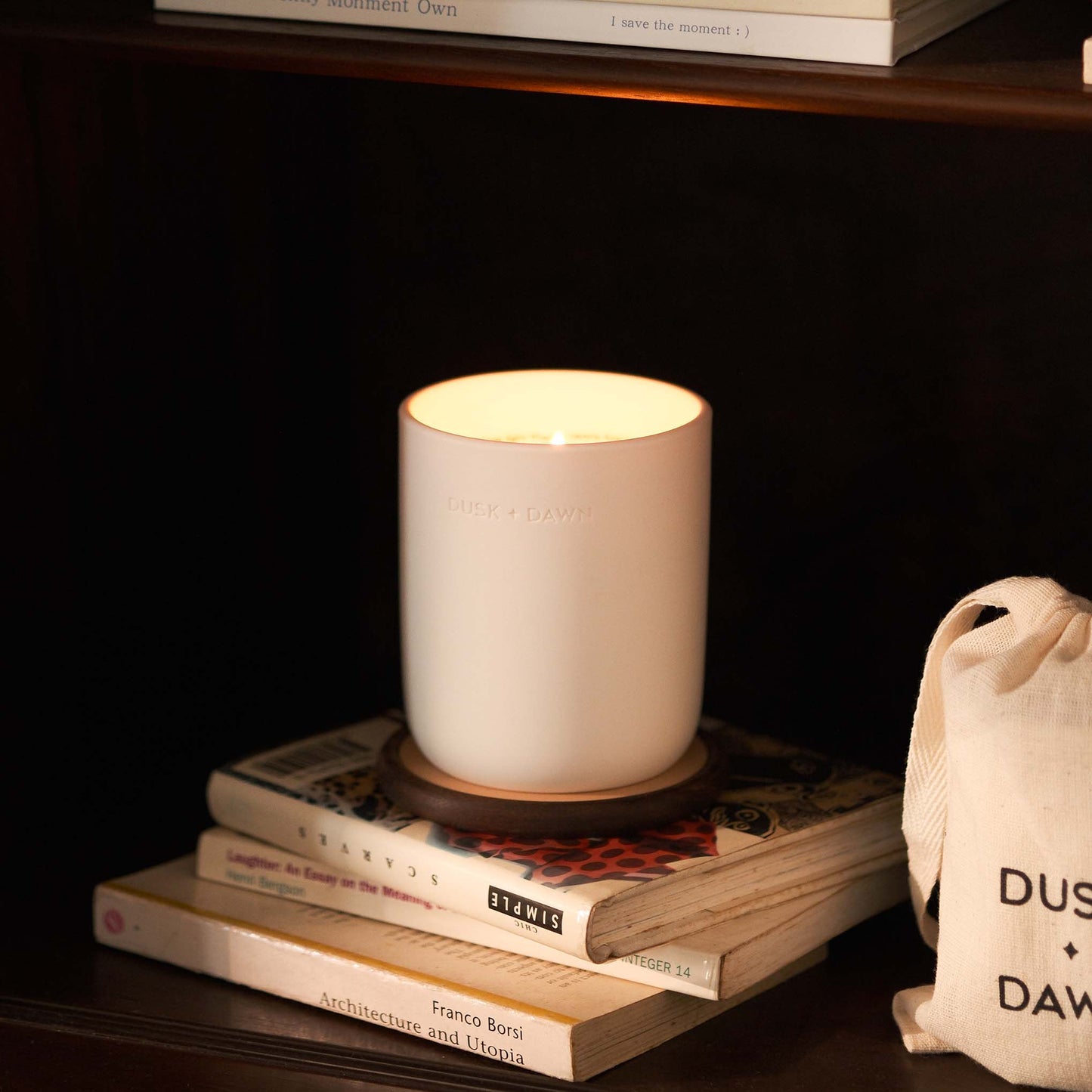 Candle on a stack of books with a dark background